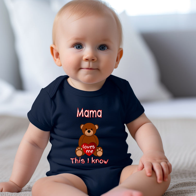 A smiling baby wearing a navy blue t-shirt with a teddy bear graphic and text that says "Mama loves this I know".
