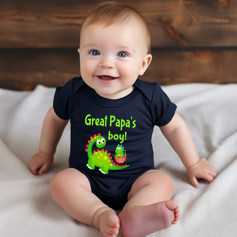A smiling baby wearing a black shirt with a dinosaur graphic and text that says "Great Papa's boy!"