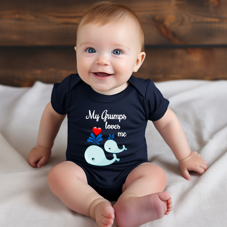 A smiling baby wearing a navy blue onesie with a cartoon whale and the text "My grumps loves me" printed on it.