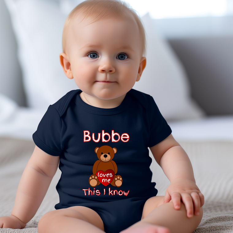 A smiling baby wearing a navy blue t-shirt with a teddy bear graphic and text.
