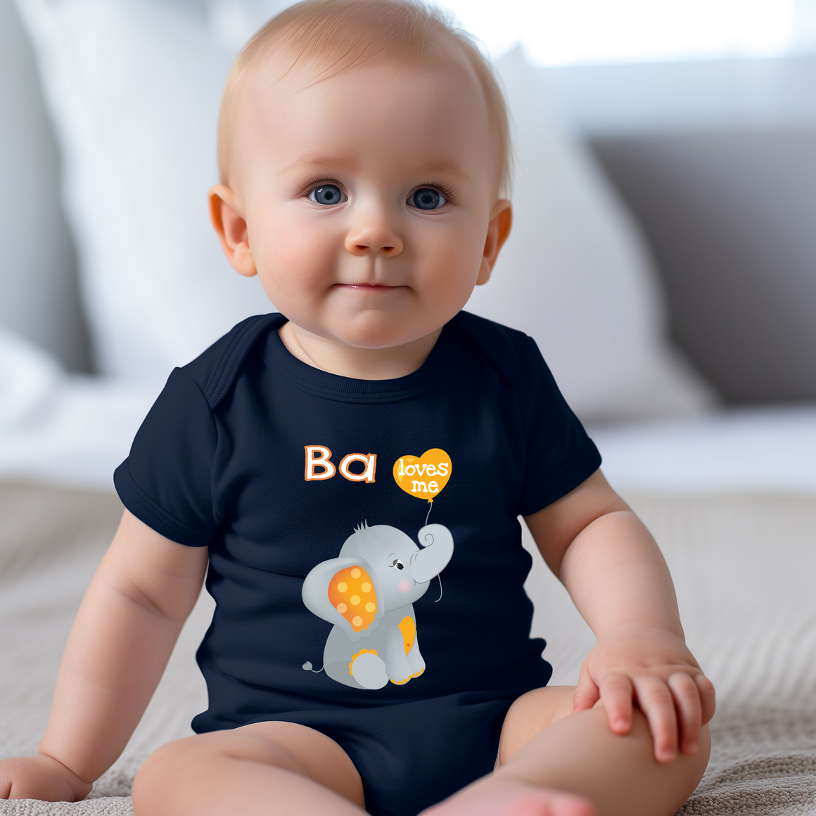 A smiling baby boy wearing a navy blue t-shirt with an elephant graphic and the text "Ba loves me" printed on it.