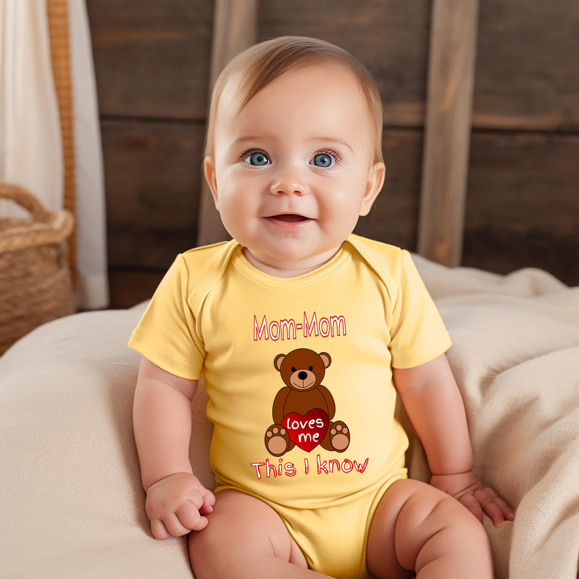A smiling baby wearing a yellow onesie with a teddy bear graphic and text.