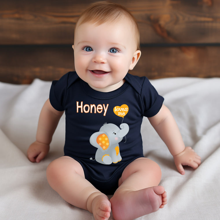 A smiling baby boy wearing a black shirt with an elephant design and the word "Honey" printed on it.