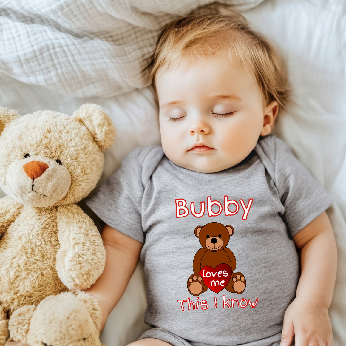 A sleeping baby wearing a gray onesie with a teddy bear and the text "Bubby loves me This I know" is pictured.