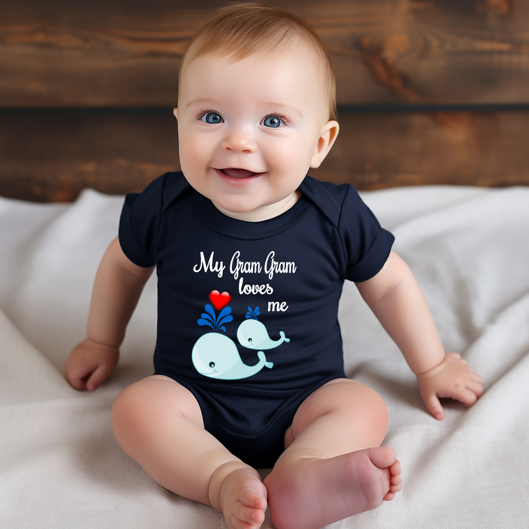 A smiling baby wearing a navy blue onesie with a whale design and the text "My Grandma loves me" printed on it.