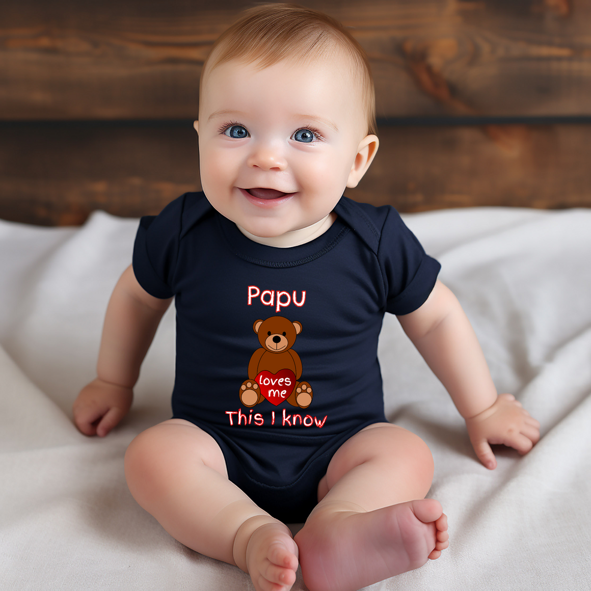 A smiling baby wearing a black t-shirt with a teddy bear graphic and text that says "Papa loves me This I know".