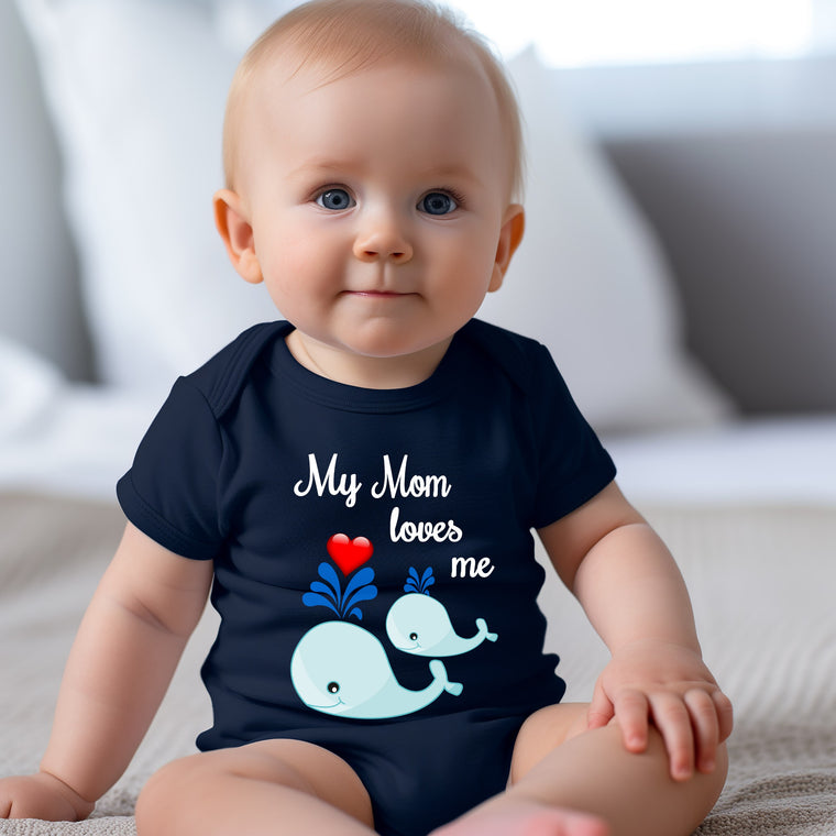 A smiling baby boy wearing a navy blue t-shirt with a whale graphic and the text "My Mom loves me" printed on it.