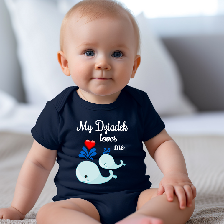 A smiling baby wearing a navy blue onesie with a whale graphic and text that says "My Dziarek loves me".