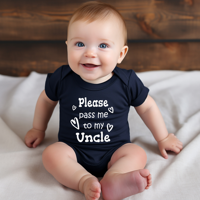 A smiling baby wearing a navy blue onesie with the text "Please pass me to my Uncle" printed on it.