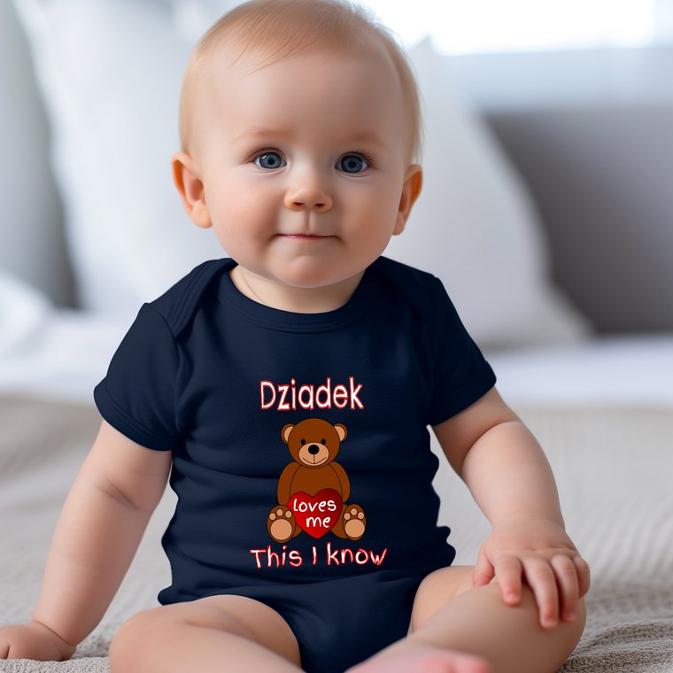 A smiling baby wearing a navy blue t-shirt with a teddy bear graphic and text.