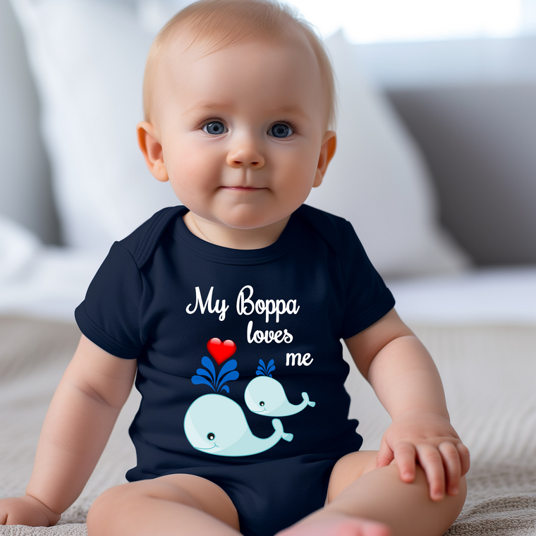 A smiling baby wearing a navy blue onesie with a whale design and text that says "My Boppa loves me".